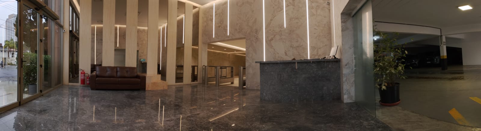 Hall de entrada do prédio da Clínica Potencial, com recepção, catraca de acesso e estacionamento interno